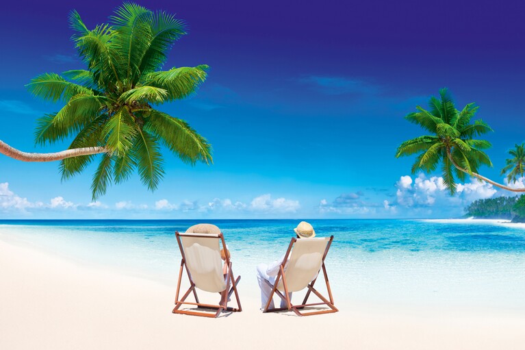 Deux personnes sur des chaises longues sur une plage de sable avec des palmiers
