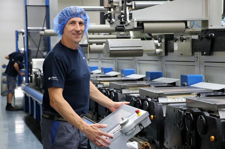 Un homme utilise une machine à imprimer des étiquettes