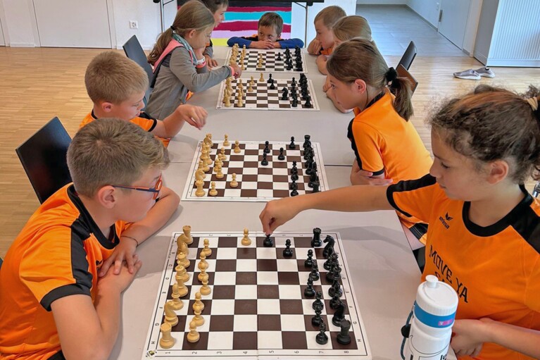 Un groupe d'enfants du camp Move-ya joue aux échecs