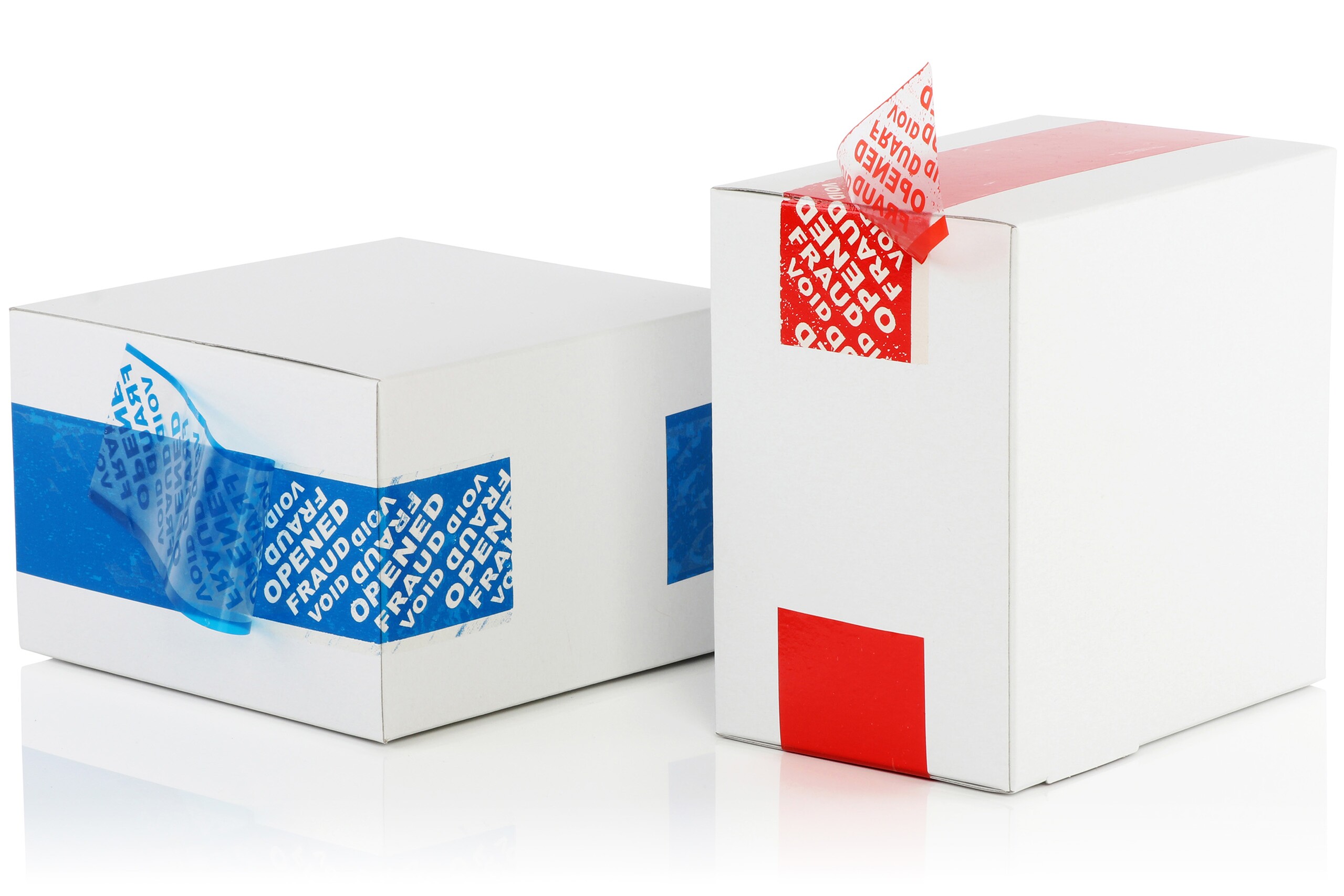 Eine Schachtel liegend und eine Schachtel stehend mit teilweise abgezogenen Sicherheitsetiketten in Blau und Rot.