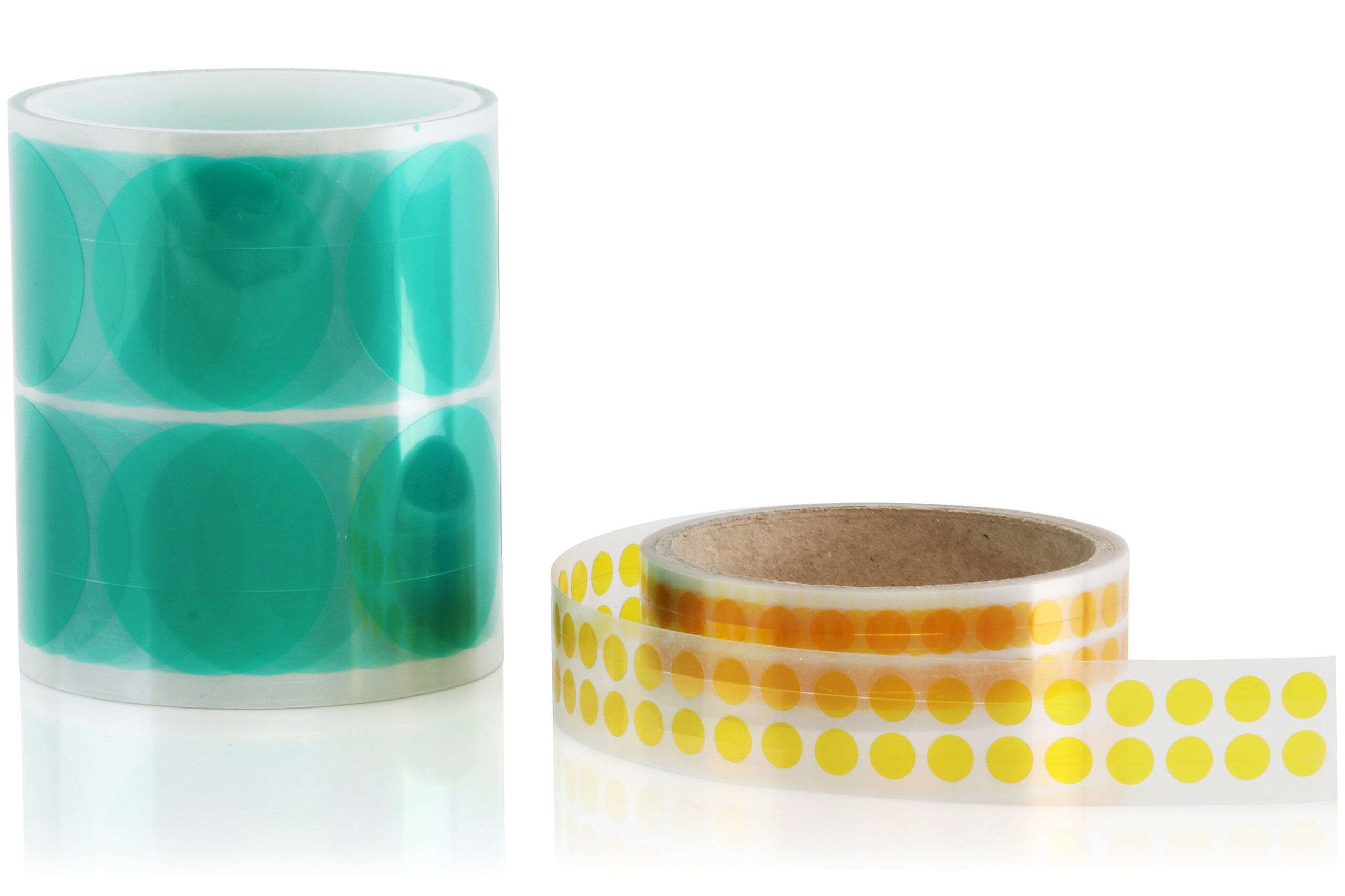 Deux rouleaux de pièces découpées rondes, transparentes en vert et transparentes en jaune.