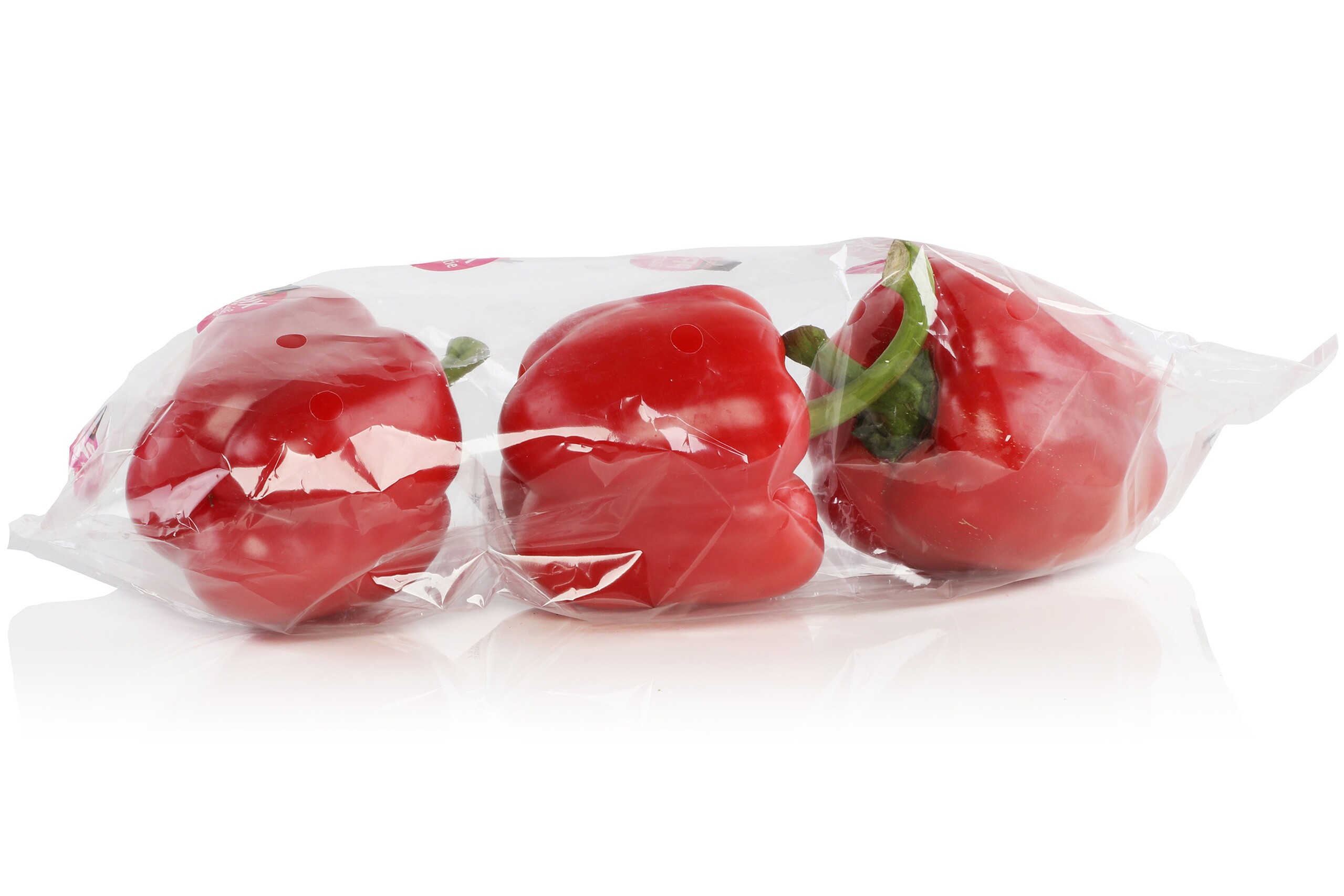 Un sachet tubulaire rempli de trois poivrons rouges.