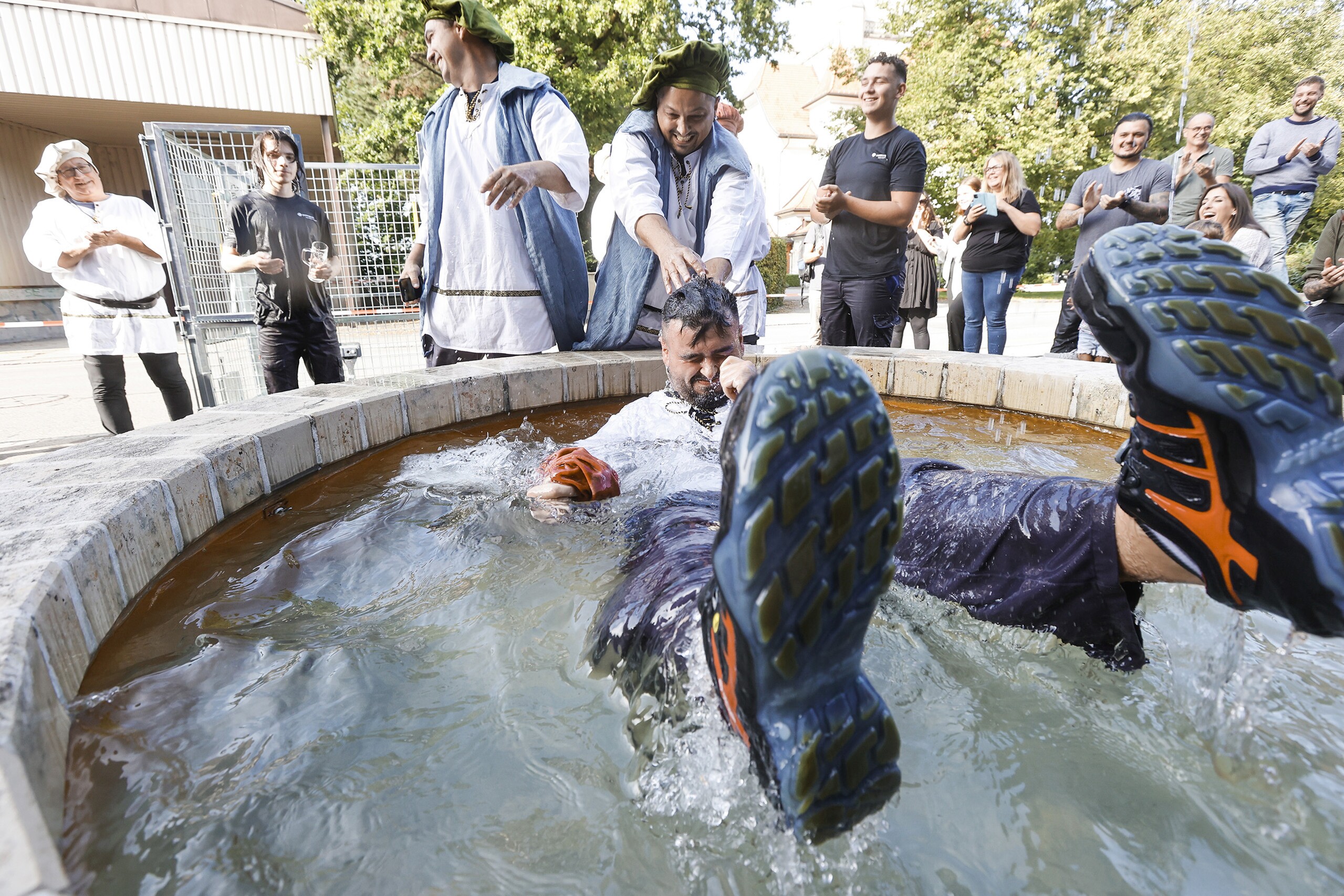 Bei einer Gautsch-Zeremonie wird ein Mann in einen mit Wasser gefüllten Brunnen getunkt.