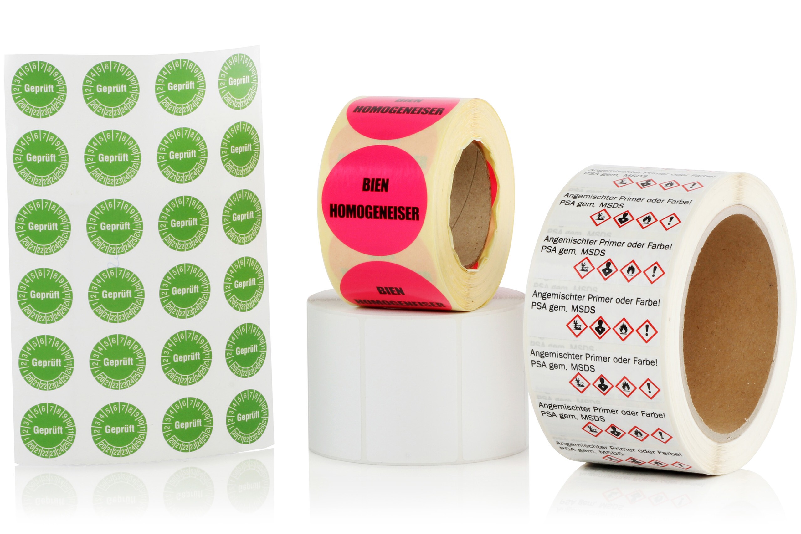 Deux rouleaux d'étiquettes imprimées en couleur, un rouleau d'étiquettes blanches et une seule feuille d'étiquettes rondes imprimées en vert et blanc.