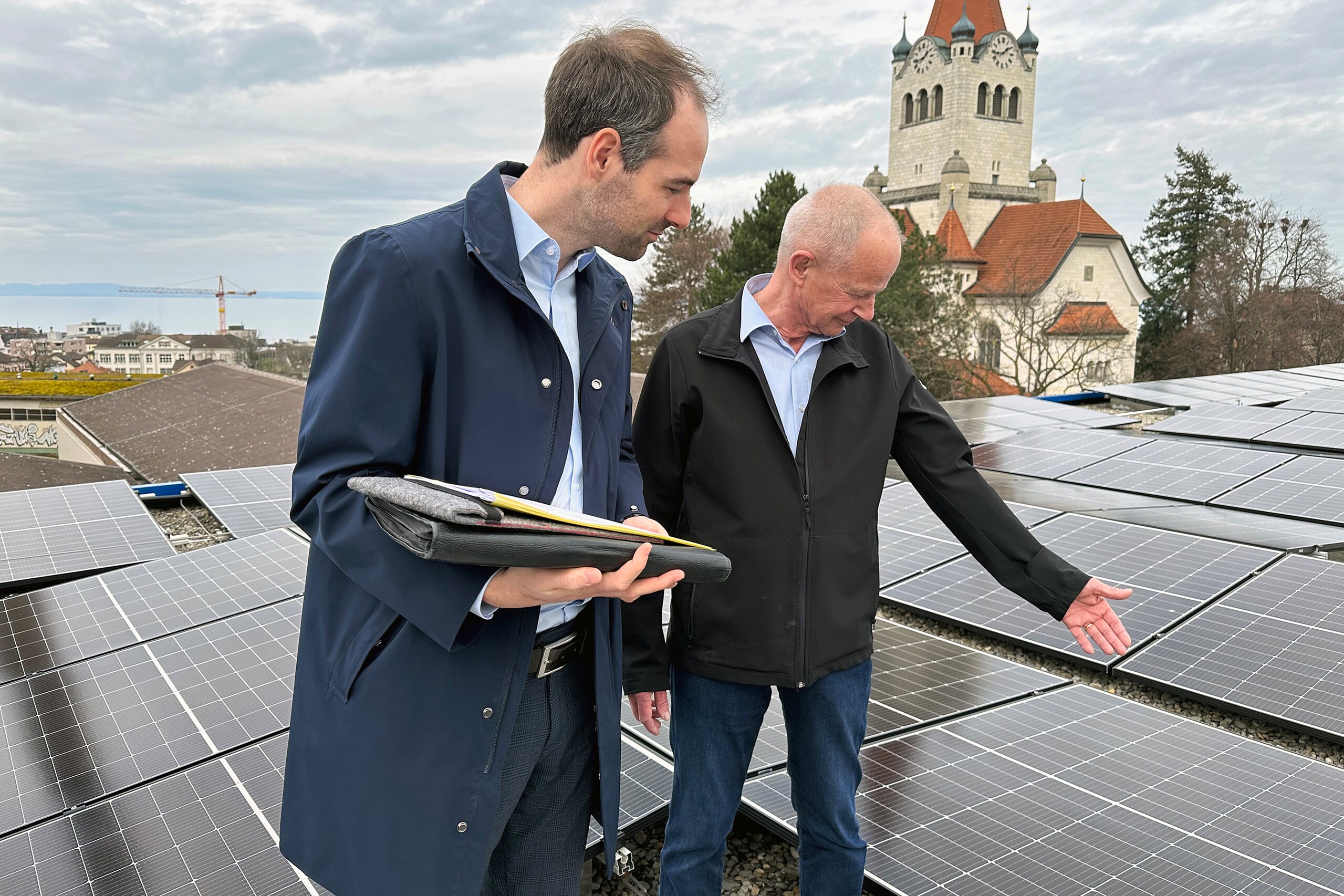 Sur le toit du hall de production: deux collaborateurs de Permapack examinent l'installation photovoltaïque.