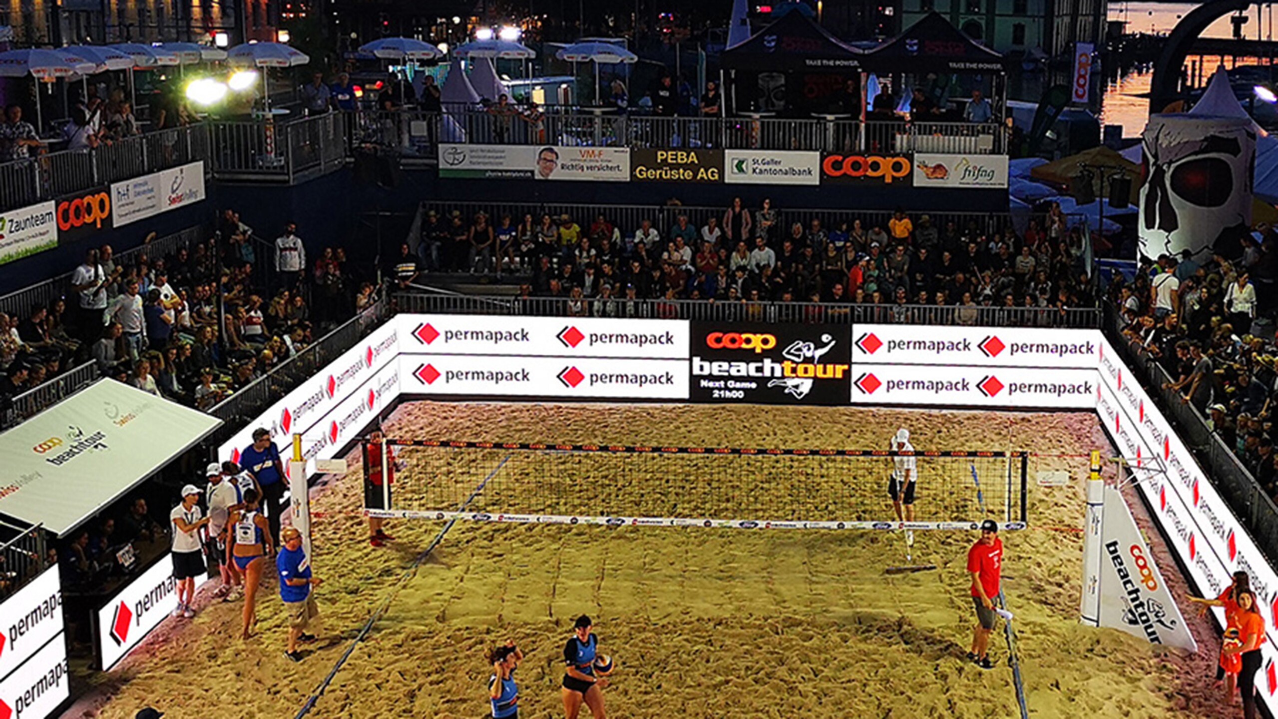 Beach Volley Ball-Spieler mit Tribüne und Permapack-Werbung im Hintergrund