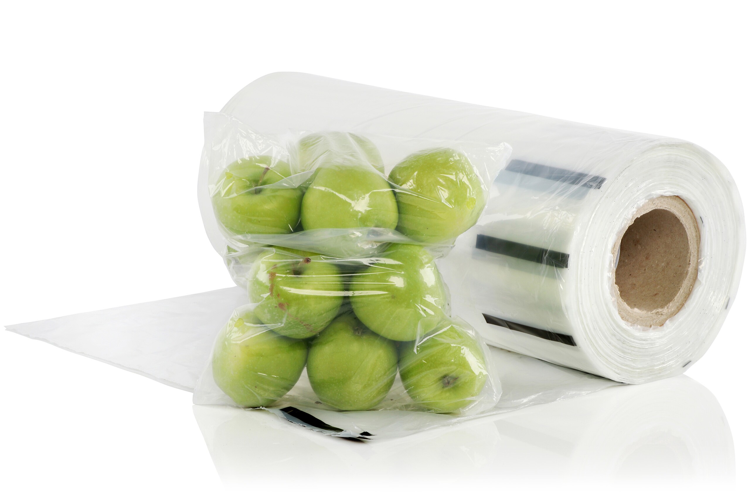 Un sachet en rouleau rempli de pommes vertes et un grand rouleau de sachets en rouleau transparents.